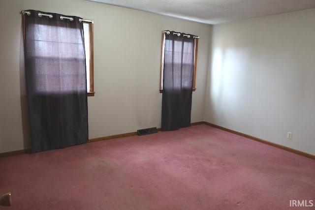 carpeted spare room with a textured ceiling