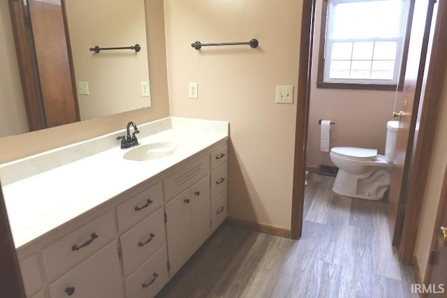 bathroom with vanity, toilet, and hardwood / wood-style floors