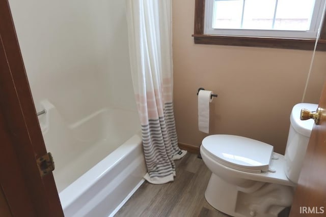 bathroom with wood-type flooring, shower / tub combo with curtain, and toilet