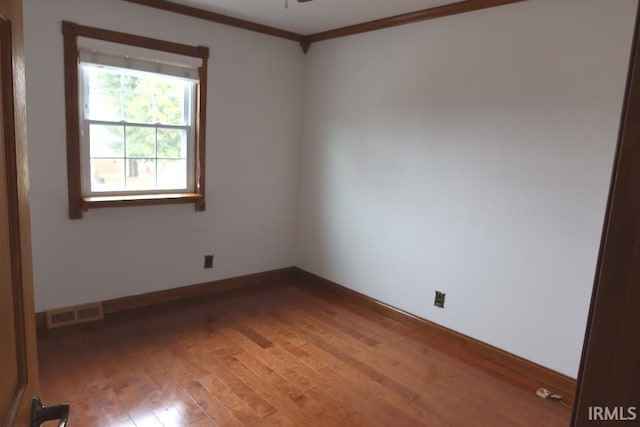 empty room with crown molding, hardwood / wood-style floors, and ceiling fan