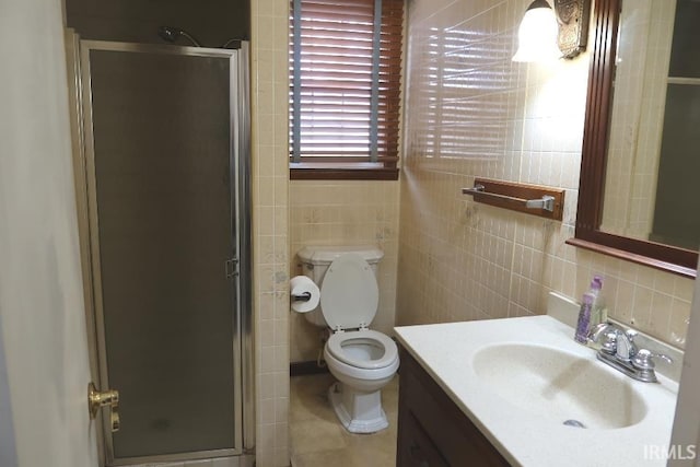 bathroom with tile walls, backsplash, vanity, a shower with shower door, and toilet