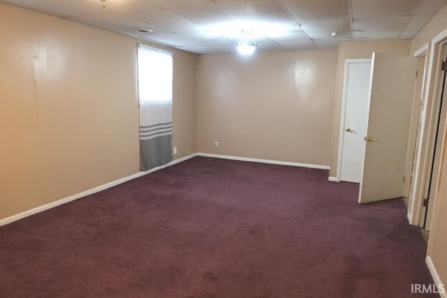 carpeted empty room featuring a paneled ceiling