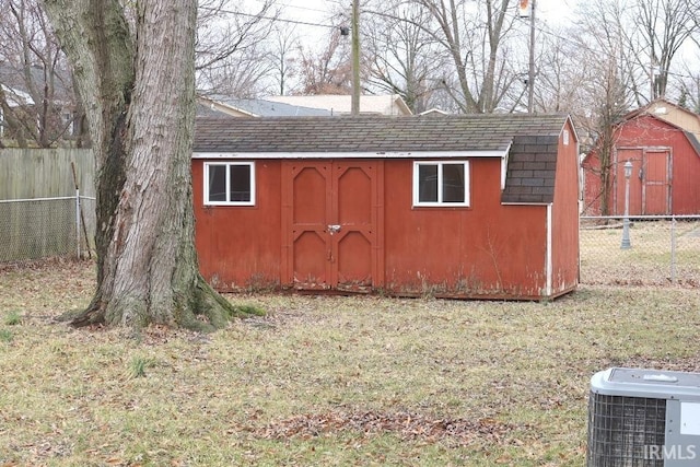 view of outbuilding featuring cooling unit and a yard