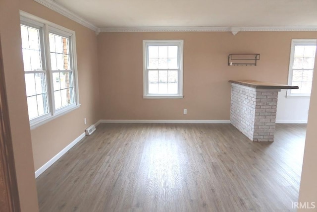 unfurnished living room featuring crown molding, plenty of natural light, and dark hardwood / wood-style floors