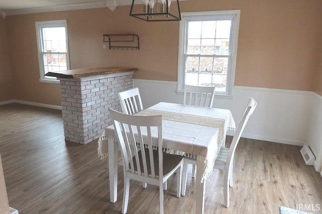 dining room featuring hardwood / wood-style flooring, ornamental molding, and a wealth of natural light