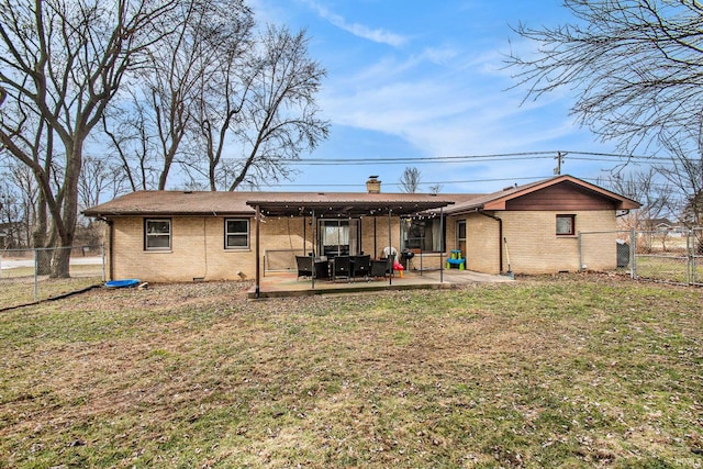 rear view of house featuring a patio area and a lawn