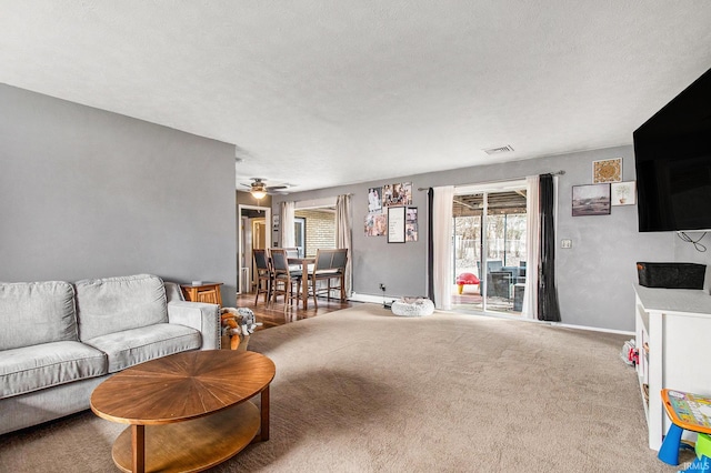 living room featuring plenty of natural light, a textured ceiling, and carpet flooring