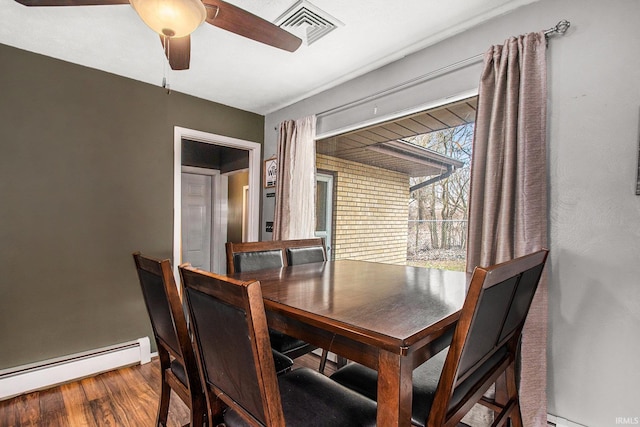 dining room featuring hardwood / wood-style flooring, ceiling fan, and baseboard heating