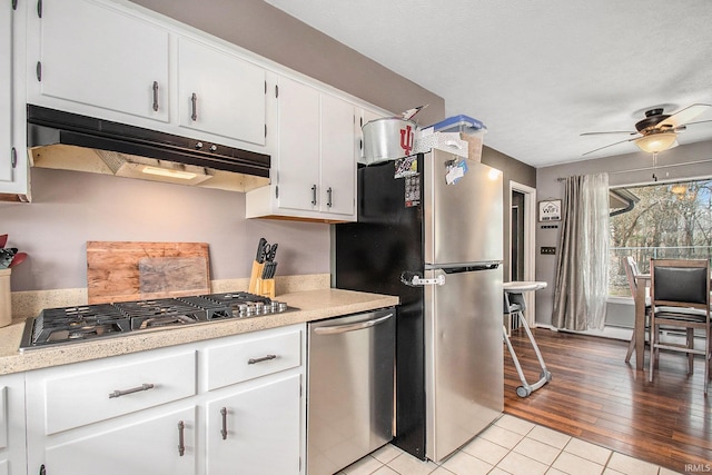 kitchen with white cabinetry, ceiling fan, stainless steel appliances, and light tile patterned floors