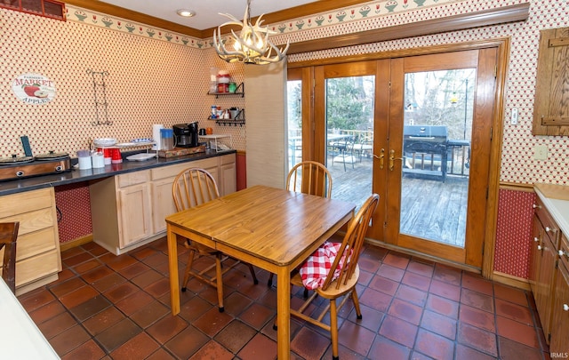 dining area with french doors, dark tile patterned flooring, and a notable chandelier