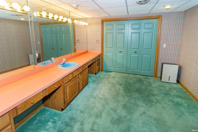 bathroom featuring a paneled ceiling and vanity