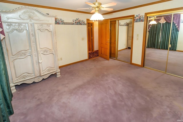 unfurnished bedroom with crown molding, ceiling fan, carpet, and two closets