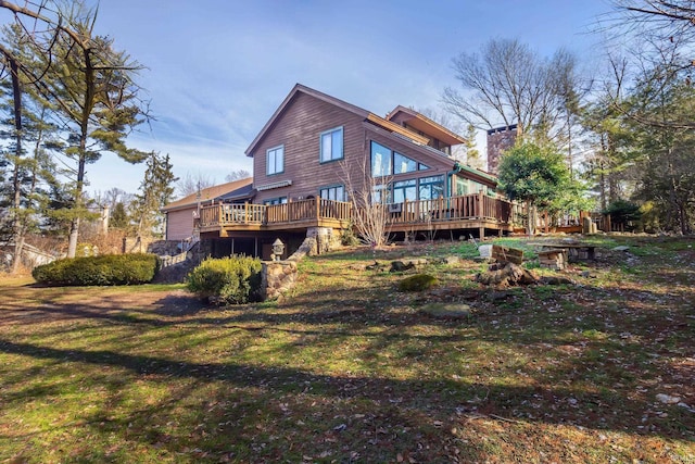 rear view of house featuring a yard and a deck