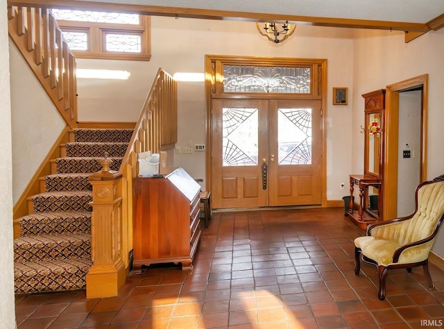 entryway featuring dark tile patterned flooring, a wealth of natural light, and french doors