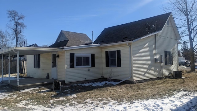 snow covered back of property featuring cooling unit