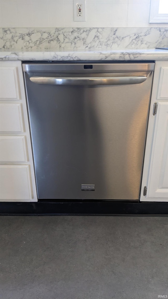 interior details with white cabinetry, light stone countertops, and stainless steel dishwasher