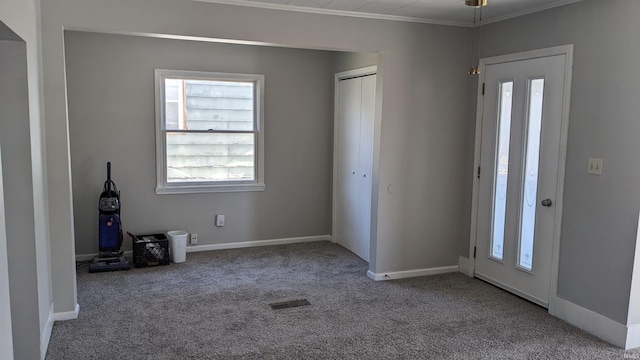 carpeted entrance foyer with crown molding