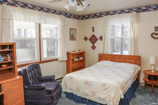 carpeted bedroom with a baseboard radiator and ceiling fan