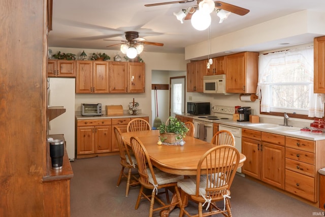 kitchen with ceiling fan, sink, pendant lighting, and white appliances