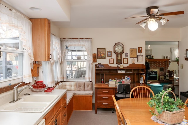 kitchen featuring sink, a fireplace, and ceiling fan