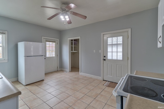 kitchen featuring light tile patterned floors, white appliances, and ceiling fan