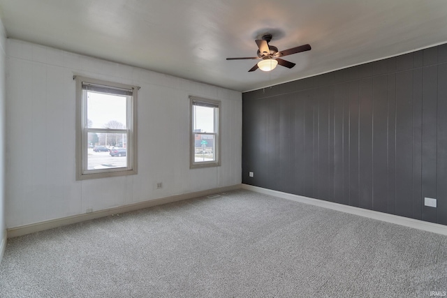 unfurnished room with ceiling fan and carpet flooring