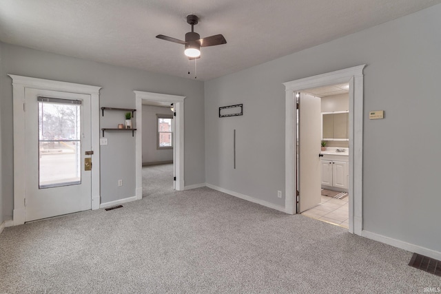 spare room featuring ceiling fan and light colored carpet