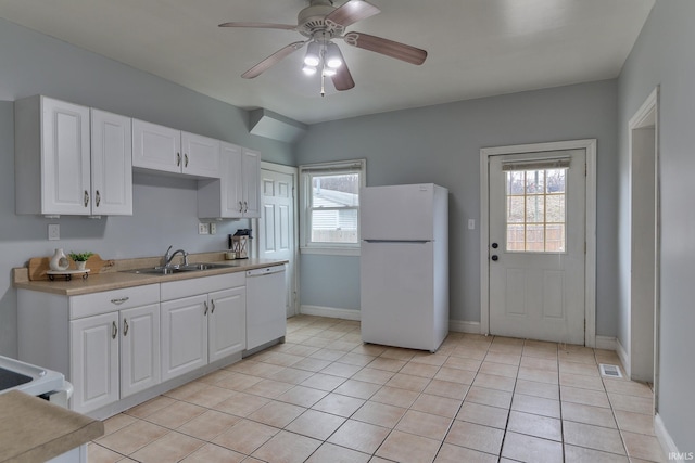 kitchen with sink, white appliances, a wealth of natural light, and white cabinets