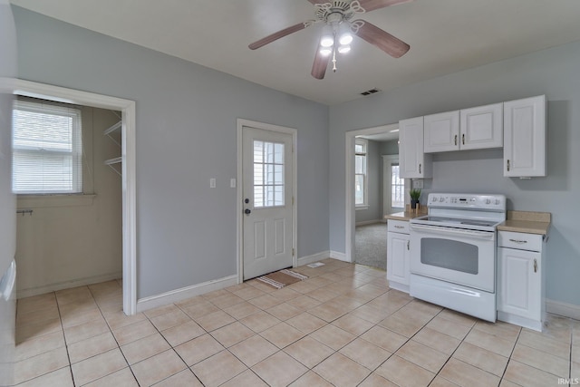 kitchen featuring white cabinetry, white range with electric cooktop, and a wealth of natural light