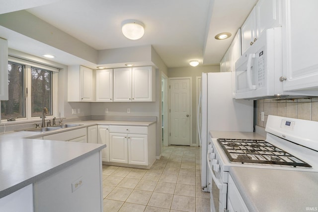 kitchen featuring light tile patterned flooring, sink, white cabinetry, white appliances, and backsplash