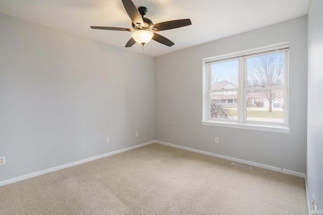 carpeted spare room featuring ceiling fan