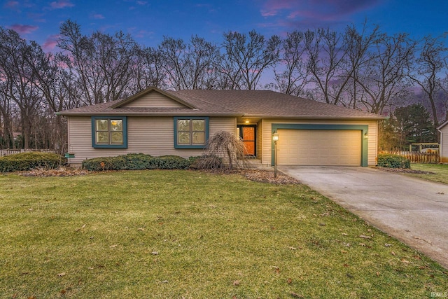 ranch-style house with a yard and a garage