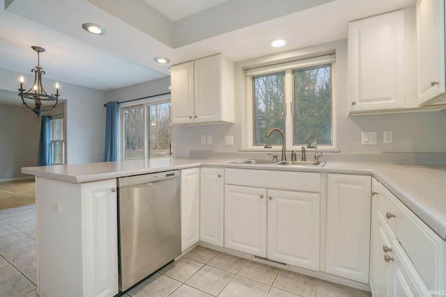 kitchen with sink, white cabinetry, decorative light fixtures, stainless steel dishwasher, and kitchen peninsula