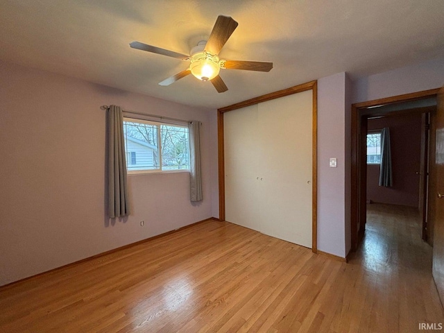 unfurnished bedroom featuring ceiling fan, light hardwood / wood-style floors, and a closet