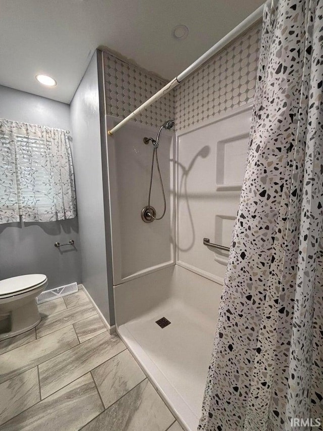 bathroom with toilet and walk in shower