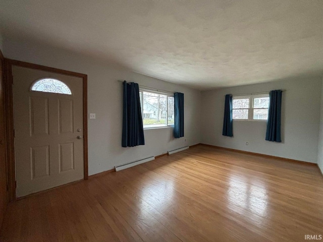 foyer entrance featuring baseboard heating and light hardwood / wood-style flooring