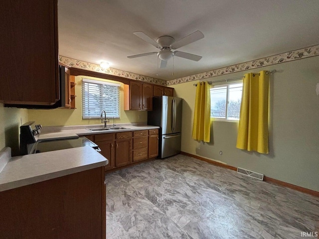 kitchen with range with electric stovetop, ceiling fan, sink, and stainless steel refrigerator