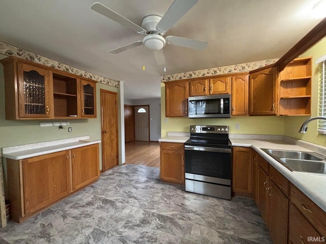 kitchen featuring ceiling fan, stainless steel appliances, and sink