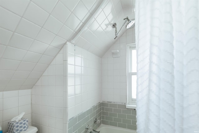 bathroom featuring lofted ceiling, shower / bath combination with curtain, and toilet