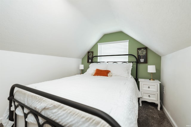 bedroom with lofted ceiling and dark carpet