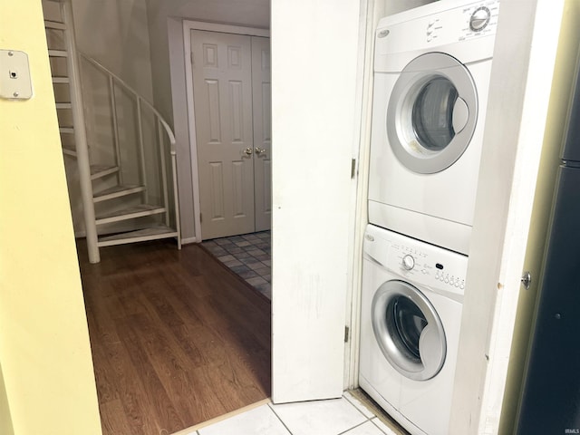 washroom featuring stacked washing maching and dryer and light wood-type flooring