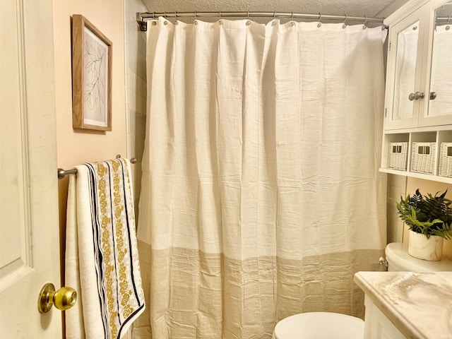 bathroom featuring vanity, toilet, and a textured ceiling