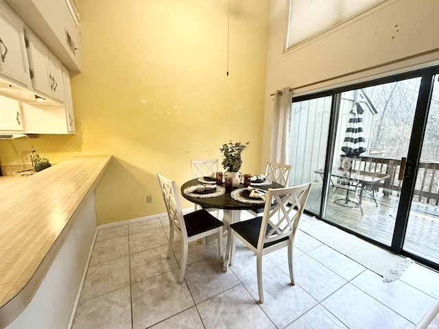 tiled dining room with a towering ceiling