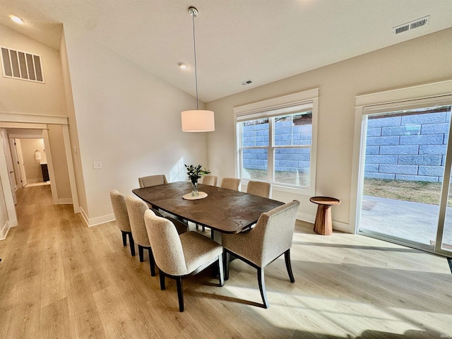 dining area with lofted ceiling and light hardwood / wood-style flooring