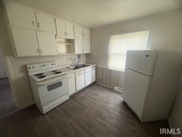 kitchen with dark hardwood / wood-style flooring, sink, white appliances, and white cabinets