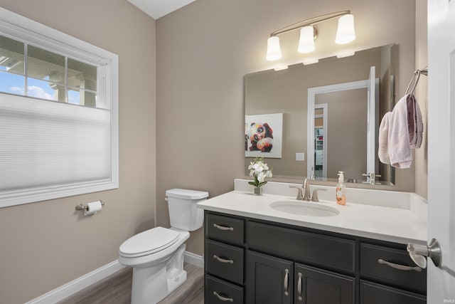 bathroom with hardwood / wood-style flooring, vanity, and toilet