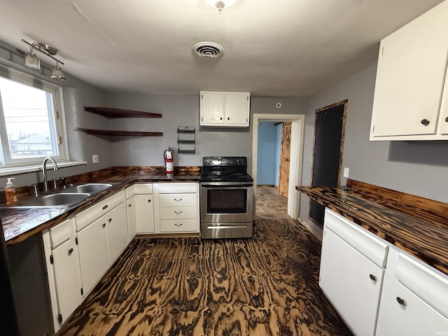 kitchen with stainless steel range with electric stovetop, sink, and white cabinets