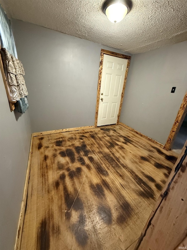 spare room featuring hardwood / wood-style flooring and a textured ceiling