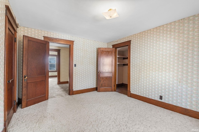 unfurnished bedroom featuring a closet and light carpet