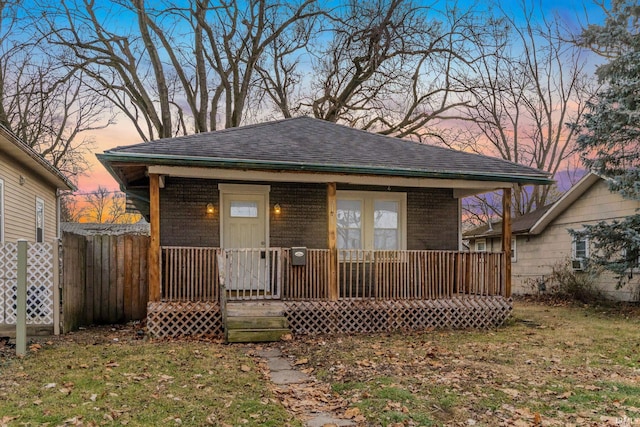 bungalow-style home with a porch and a lawn